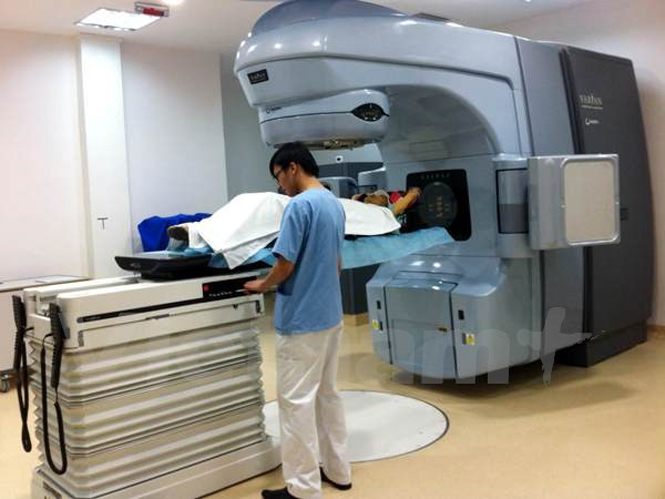Nhân viên y tế vận hành máy xạ trị gia tốc tuyến tính hiện đại nhất Việt Nam Varian Clinac iX để điều trị cho bệnh nhân. (Ảnh: T.G/Vietnam+)