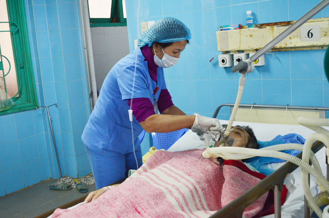 Điều dưỡng Hoàng Thị Vình chăm sóc cho bệnh nhân hôn mê sâu.