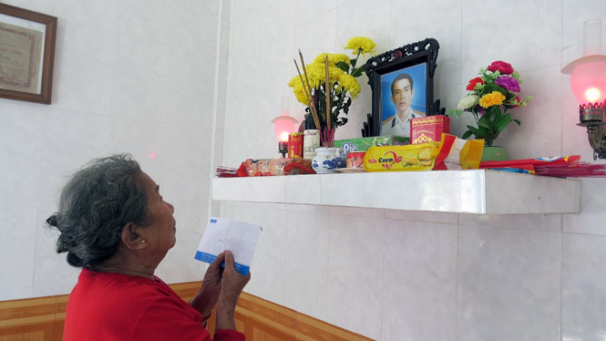 Bà Hồ Thị Đức, mẹ anh hùng liệt sĩ Trần Văn Phương đặt phần quà của Báo Tuổi Trẻ lên bàn thờ con.
