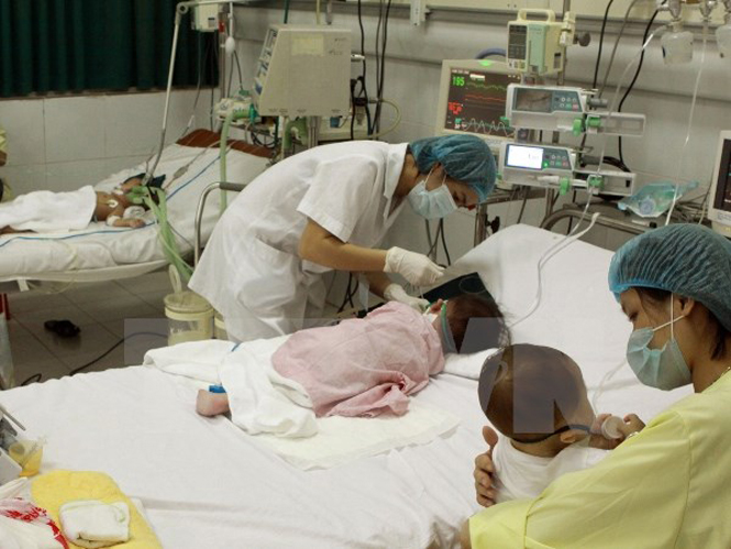 Nhân viên y tế chăm sóc cho bệnh nhân nhi. (Ảnh: TTXVN)