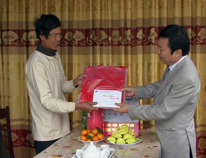 Đồng chí Trần Đình Dinh, Chủ tịch UBND thành phố trao quà tết cho gia đình chính sách.