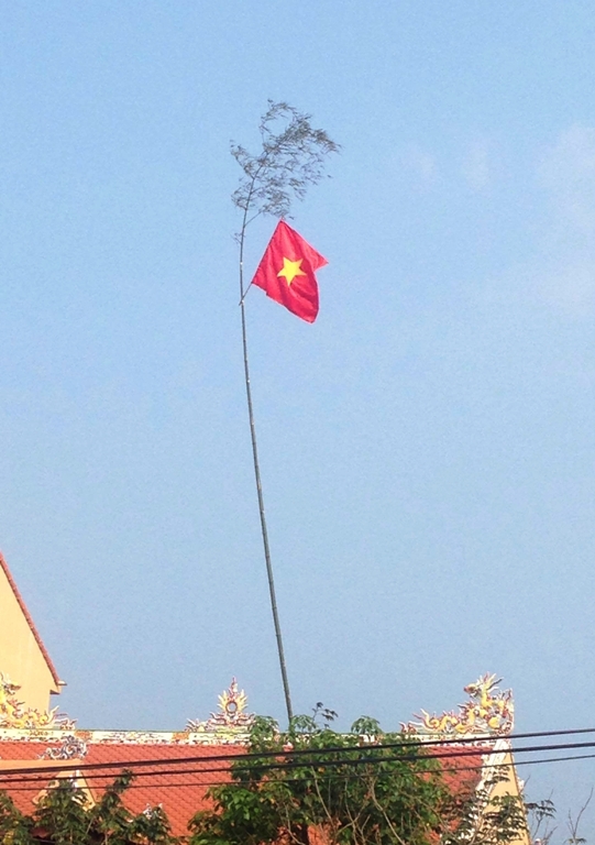Cây nêu truyền thống hòa quyện cùng sắc màu cờ đỏ rực rỡ!