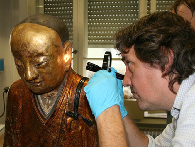  Một chuyên viên nghiên cứu khám nghiệm bức tượng có niên đại từ thế kỷ 11.
