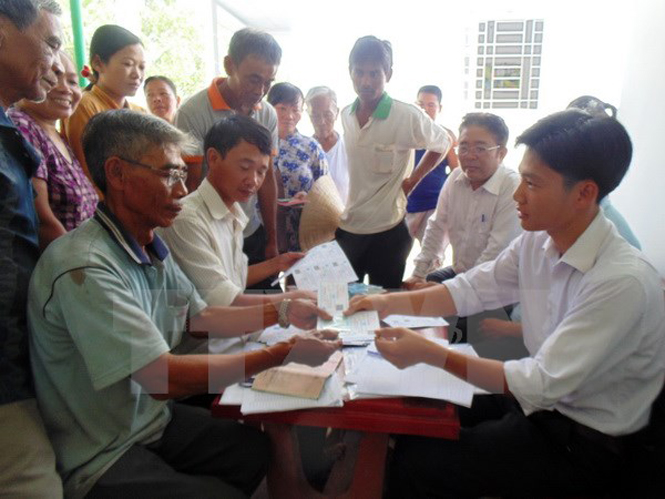 Cấp thẻ Bảo hiểm y tế cho hộ dân tộc thiểu số tại xã Vĩnh Trung, huyện Vị Thủy, Hậu Giang. (Ảnh: TTXVN phát)