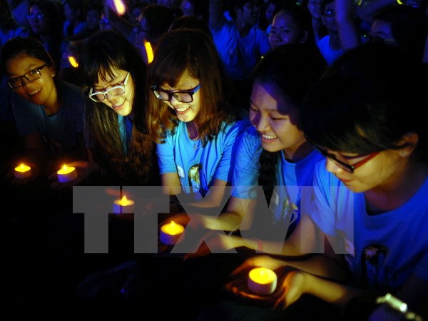 Các tình nguyện viên tại Thành phố Hồ Chí Minh thắp đèn led, hưởng ứng chiến dịch Giờ Trái Đất. (Ảnh: Mạnh Linh/TTXVN)