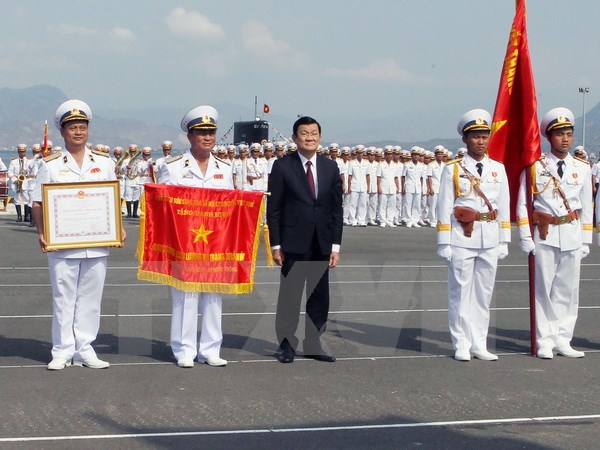 Chủ tịch nước Trương Tấn Sang gắn huy hiệu Anh hùng lực lượng Vũ trang Nhân dân lên Quân kỳ Quyết thắng của lực lượng Hải quân nhân dân Việt Nam. (Ảnh: Nguyễn Khang/TTXVN)
