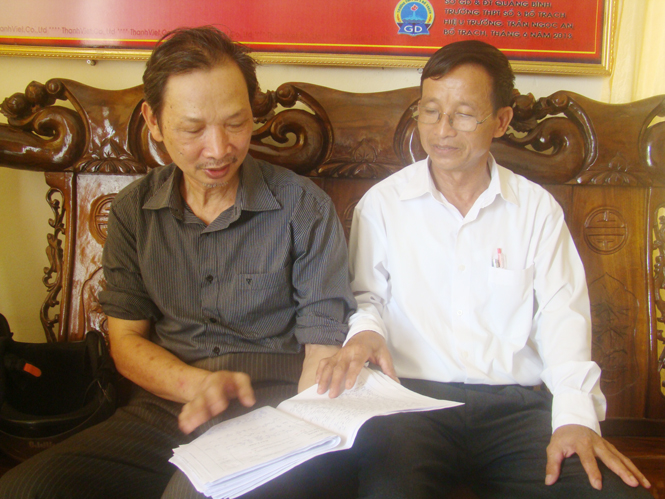 Thầy giáo Trần Ngọc An (áo trắng) đang trao đổi với thầy giáo cũ của mình về những bài văn hay của học sinh.