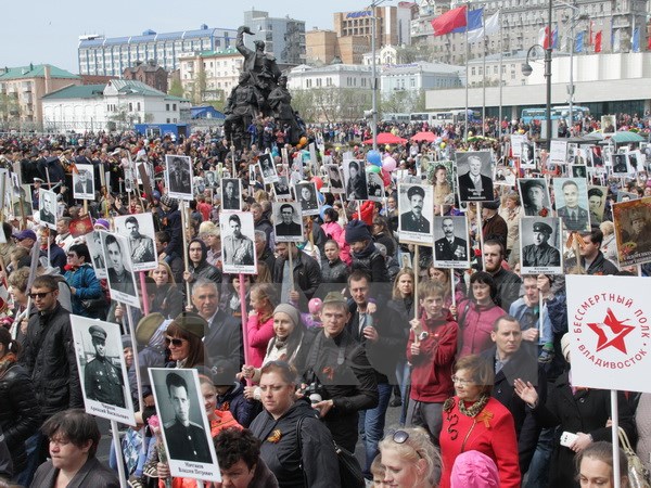 Người dân Nga mang ảnh người thân hy sinh trong Chiến tranh Thế giới thứ II tại lễ kỷ niệm 70 năm Ngày Chiến thắng ở thành phố Vladivostok ngày 9/5. (Nguồn: THX/TTXVN)