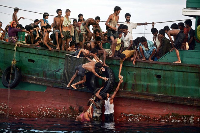 Người tị nạn Rohingya vớt đồ ăn được thả từ trực thăng. (Ảnh: AFP)