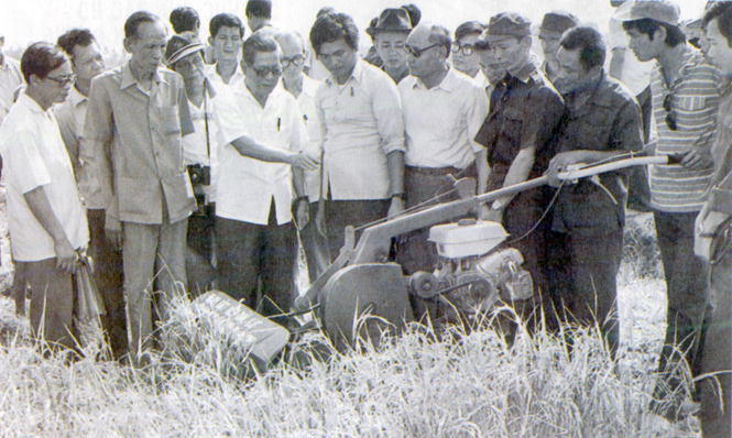 Tổng Bí thư Nguyễn Văn Linh xem máy cắt lúa trên đồng ruộng của HTX Phước Tú, huyện Bến Lức, tỉnh Long An (năm 1988). Ảnh: Tư liệu