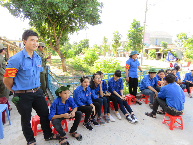 Lực lượng thanh niên tình nguyện TP.Đồng Hới túc trực từ sáng sớm tại các điểm thi để sẵn sàng hướng dẫn và giúp đỡ thí sinh đến trường thi. (Ảnh: N.H)