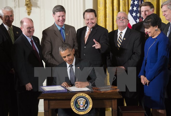 Tổng thống Barack Obama (giữa, ngồi) ký ban hành Đạo luật về quyền đàm phán nhanh. (Nguồn: AFP/TTXVN)