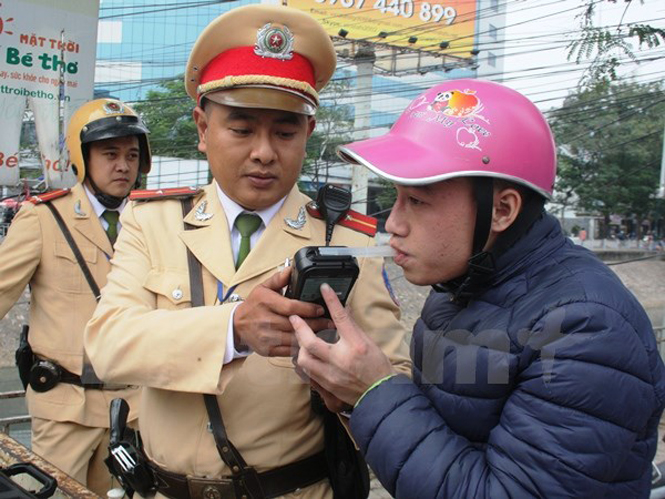 Cảnh sát giao thông tiến hành đo nồng độ cồn của người điều khiển phương tiện. (Ảnh: Việt Hùng/Vietnam+)