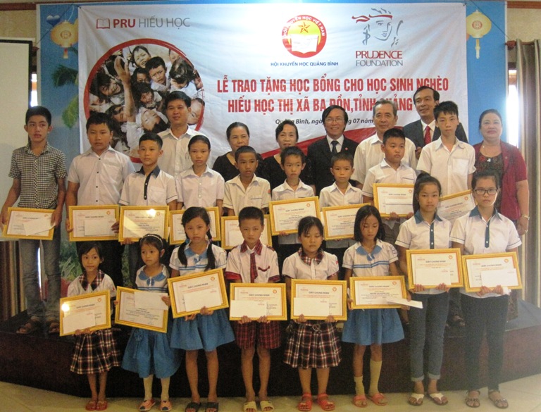 Đại diện lãnh đạo Công ty BHNT Prudential và thị xã Ba Đồn trao học bổng cho các em học sinh