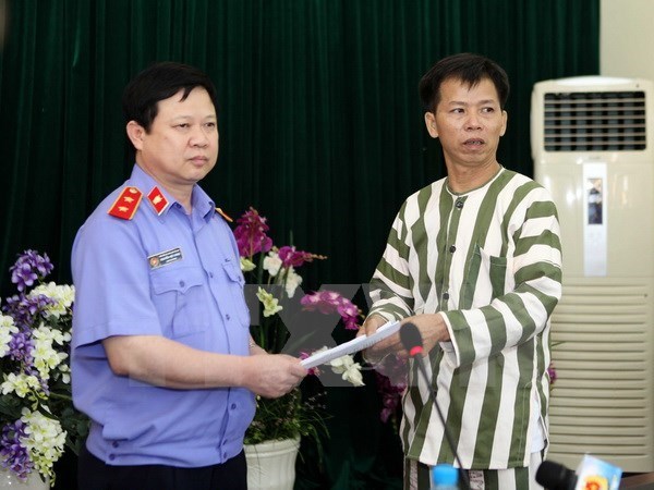 Chánh văn phòng Viện Kiểm sát Nhân dân Tối cao Nguyễn Việt Hùng trao quyết định tạm đình chỉ thi hành án đối với ông Nguyễn Thanh Chấn. (Ảnh: Doãn Tấn/TTXVN)