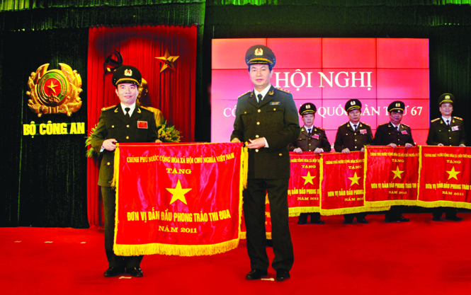 Đại tướng Trần Đại Quang, Ủy viên Bộ Chính trị, Bộ trưởng Bộ Công an, trao cờ đơn vị dẫn đầu phong trào thi đua năm 2011 cho Công an tỉnh Quảng Bình.