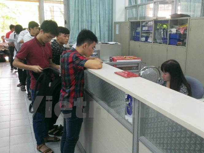 Thí sinh xếp hàng xin rút hồ sơ tại Đại học Bách khoa Hà Nội sáng 14-8. (Ảnh: Phạm Mai/Vietnam+)