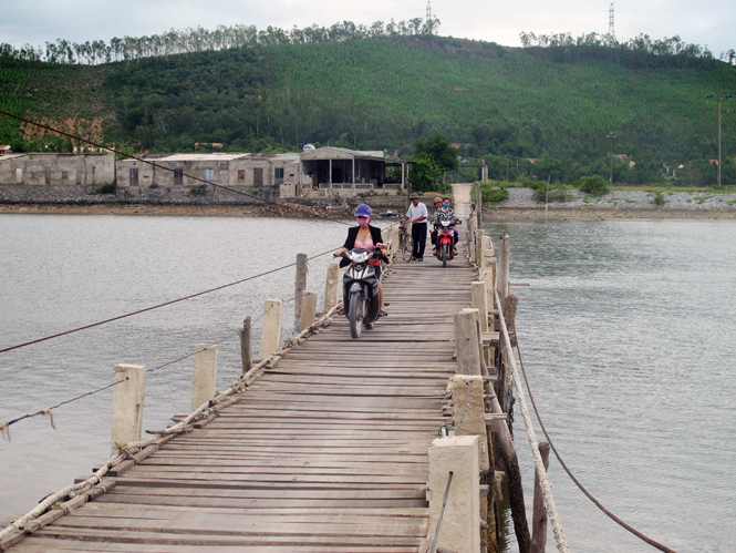 Người dân thôn Thuận Hòa qua lại trên cây cầu phao đã xuống cấp bất chấp nguy hiểm chực chờ.