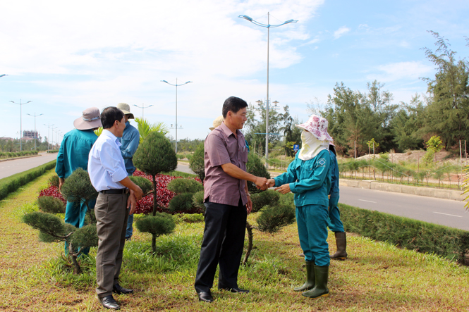 Đồng chí Phó Bí thư Thường trực Thành ủy thăm hỏi, động viên cán bộ công nhân viên Trung tâm Công viên-Cây xanh Đồng Hới đang chăm sóc hệ thống cây cảnh trên đường Đại tướng Võ nguyên Giáp.