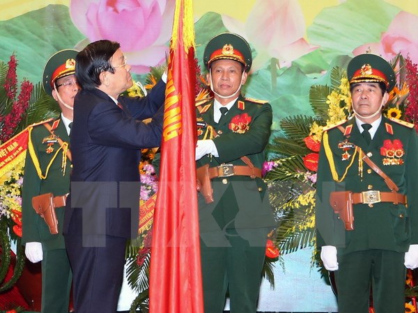 Chủ tịch nước Trương Tấn Sang gắn Huân chương Quân Công hạng Nhất lên Cờ truyền thống của Bộ Tổng tham mưu Quân đội nhân dân Việt Nam. (Ảnh: Nguyễn Khang/TTXVN)