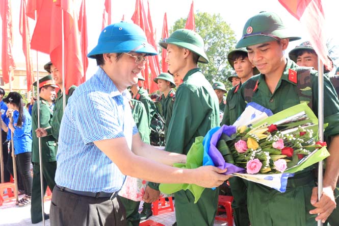 Đồng chí Trần Tiến Dũng, TUV, Phó Chủ tịch UBND tỉnh tặng hoa động viên các tân binh lên đường làm nhiệm vụ.