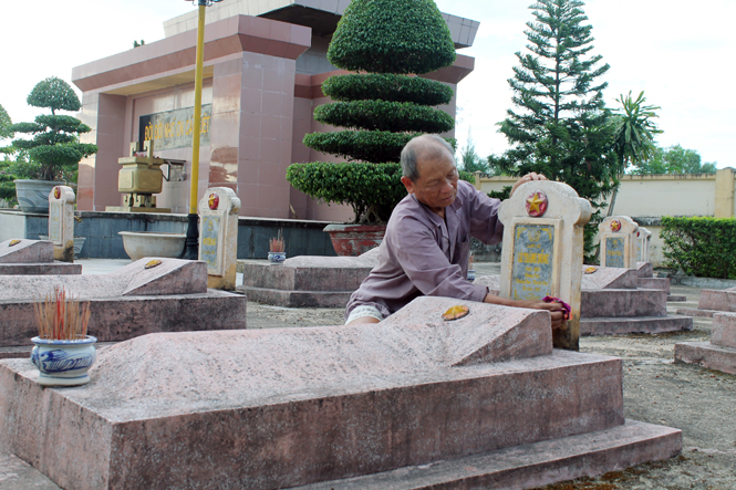  Ông Trương Văn Giỏi đang lau những tấm bia mộ các liệt sỹ.