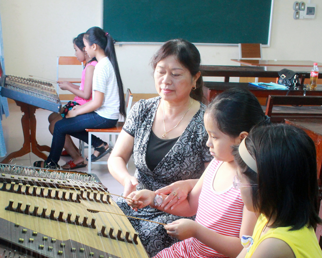 Cô Minh Hới hướng dẫn các em học môn đàn tam thập lục.