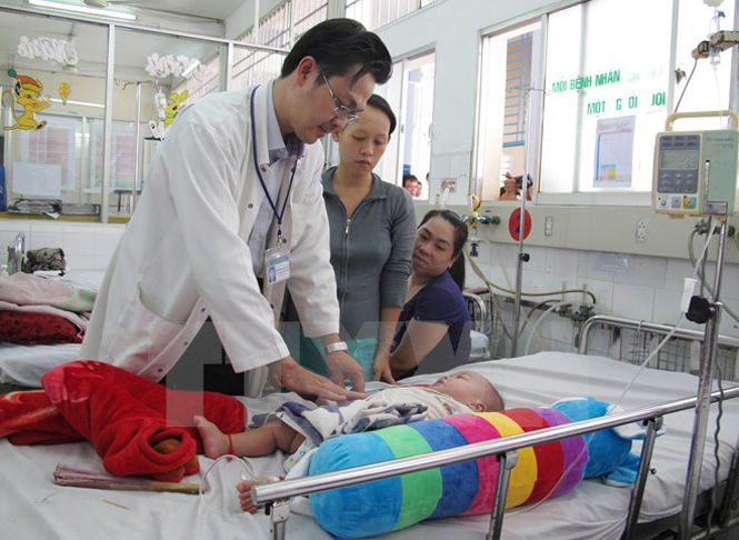 Bác sĩ bệnh viện Nhi Đồng 1 thăm khám cho bệnh nhi bị sốt xuất huyết. (Ảnh: Phương Vy/TTXVN)