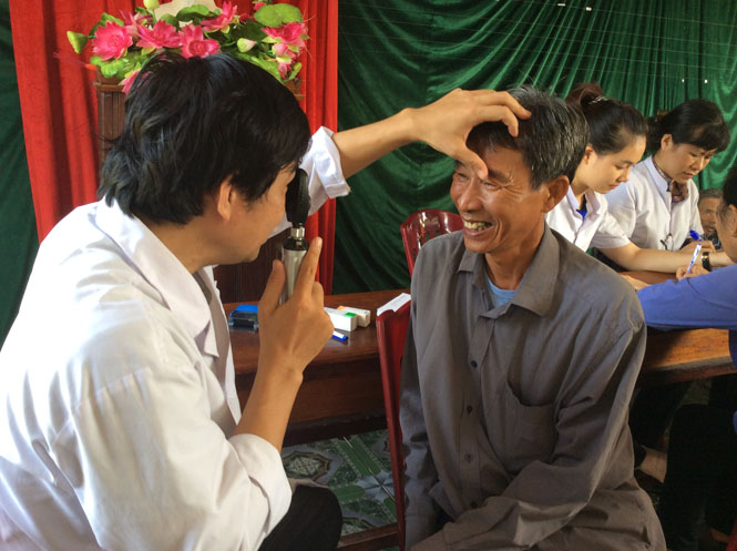 Cán bộ y tế Trung tâm phòng chống bệnh xã hội đang tiến hành khám sàng lọc các bệnh về mắt cho người cao tuổi ở xã Hải Ninh.