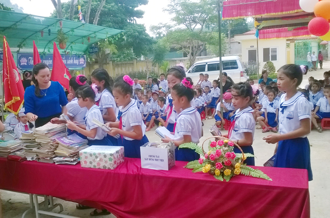 Các em học sinh quyên góp sách xây dựng thư viện trường học vùng khó khăn nhân “Tuần lễ hưởng ứng học tập suốt đời” năm 2015 tại huyện Minh Hóa.