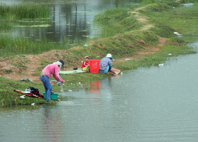 Ảnh 2 : Để tiết kiệm tiền mua nước sinh hoạt hàng ngày, nhiều hộ dân thôn Nam Sơn buộc phải ra sông và các dòng kênh để tắm giặt.