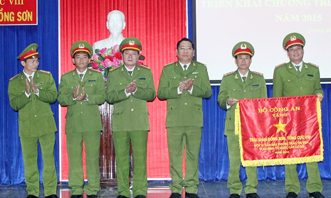 Ảnh 6 : Trung tướng Hồ Thanh Đình, Phó Tổng cục trưởng Tổng cục VIII trao tặng cờ đơn vị dẫn đầu phong trào thi đua “Vì an ninh Tổ quốc” cấp cơ sở năm 2014 cho Trại giam Đồng Sơn.