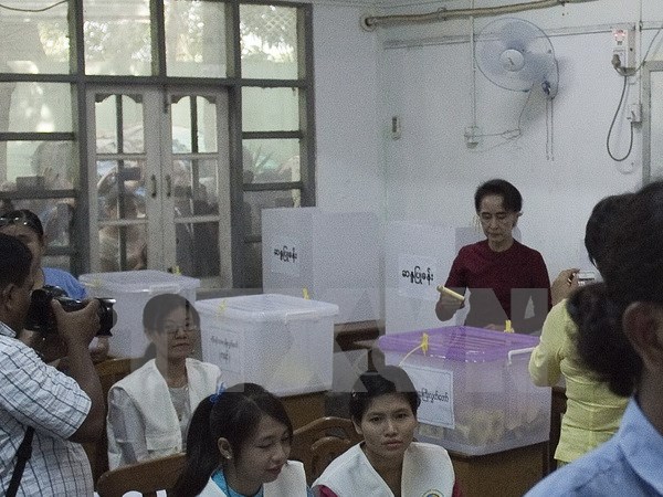 Bà Aung San Suu Kyi (phải), người đứng đầu Liên minh quốc gia vì dân chủ (NLD) đối lập bỏ phiếu tại điểm bầu cử ở Yangon ngày 8/11. (Nguồn: AFP/TTXVN)