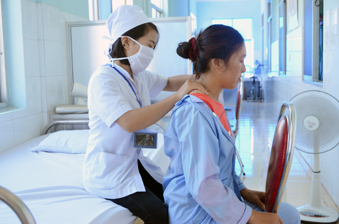 Nữ cán bộ y tế tận tình chăm sóc, phục hồi chức năng cho người bệnh.