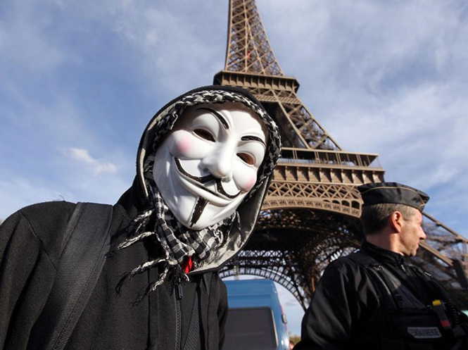 Một người biểu tình đeo mặt nạ Anonymous Guy Fawkes, biểu tượng của Anonymous trong một cuộc tuần hành dưới chân tháp Eiffel, Paris. (Nguồn: AFP)