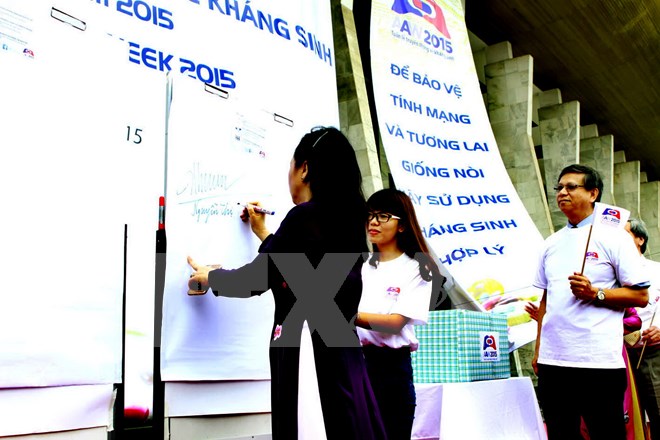 Bộ trưởng Bộ Y tế Nguyễn Thị Kim Tiến ký cam kết phòng chống kháng thuốc. (Ảnh: Dương Ngọc/TTXVN)