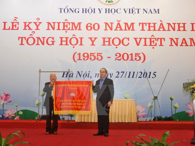 Chủ tịch Mặt trận Tổ quốc Việt Nam Nguyễn Thiện Nhân trao tặng bức trướng cho Tổng hội Y học VIệt Nam. (Ảnh: Quốc Khánh/TTXVN)