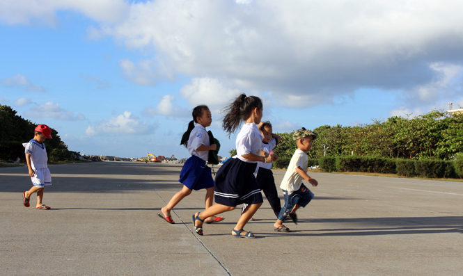 Ảnh 7: Những đứa trẻ Trường Sa vui đùa trên đường băng sân bay của đảo.