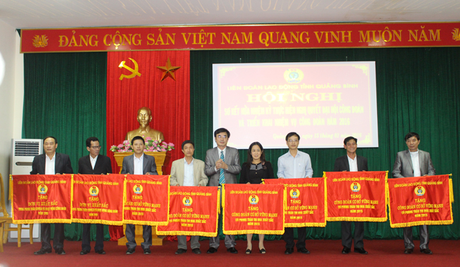 Đồng chí Nguyễn Lương Bình, Chủ tịch LĐLĐ tỉnh tặng cờ thi đua cho các tập thể có thành tích xuất sắc trong phong trào thi đua yêu nước và hoạt động công đoàn.