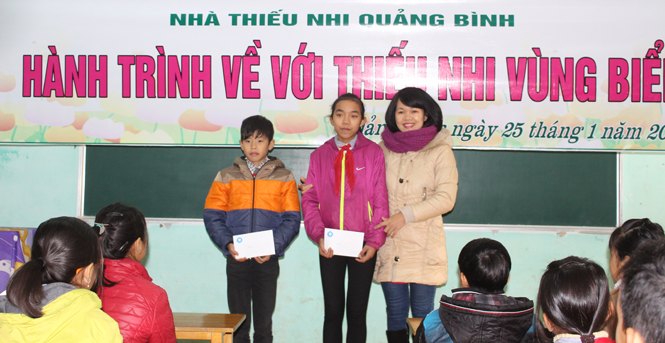Đại diện Nhà Thiếu nhi tỉnh tặng quà cho các em học sinh có hoàn cảnh đặc biệt khó khăn vượt khó học giỏi của Trường THCS Bảo Ninh.