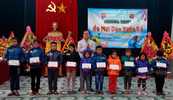Anh Trần Vũ Phong, Bí thư huyện Đoàn Quảng Trạch trao quà cho các em học sinh có hoàn cảnh khó khăn.