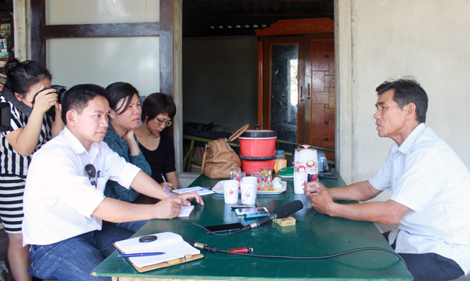 Phóng viên Báo Quảng Bình đang trao đổi với người dân Quảng Trị về Dự án Dân chấm điểm.