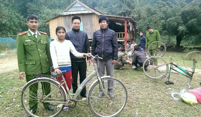 Cán bộ chiến sỹ Đồn Công an Tân Ấp trao xe đạp đã được sửa cho một em học sinh dân tộc thiểu số bản Cáo.