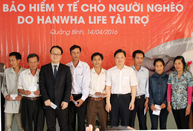 Ông Nguyễn Tiến Hoàng, Phó Chủ tịch UBND tỉnh cùng đại diện lãnh đạo công ty Bảo hiểm Hanwha Life trao thẻ BHYT cho người cận nghèo