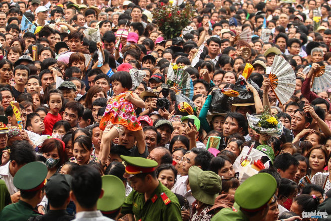 Một bé gái được người thân bế lên cao để đưa vào khu vực cách ly, rất nhiều trẻ nhỏ đã bị khó thở do lượng người đến lễ hội Đền Hùng quá lớn - Ảnh: Nguyễn Khánh
