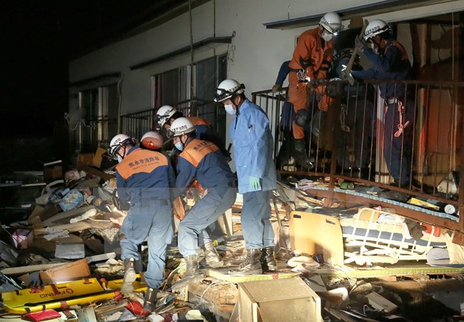 Nhân viên cứu hộ cứu một người bị mắc kẹt trong những đống đổ nát sau trận động đất ở Kuammoto ngày 16-4. (Nguồn: AFP/TTXVN)