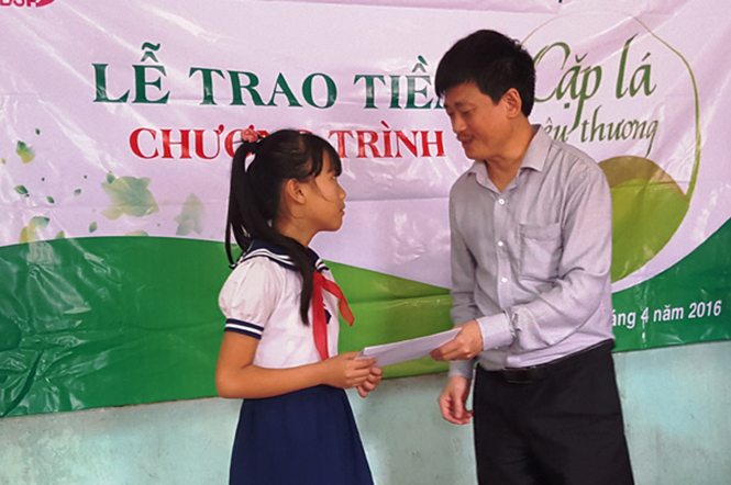 Đại diện lãnh đạo NHCSXH tỉnh Quảng Bình trao tiền hỗ trợ của chương trình 