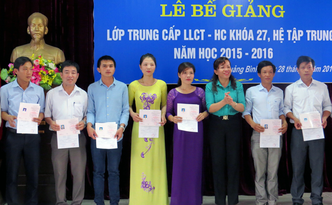 Đồng chí Nguyễn Thị Minh, TUV, Hiệu trưởng Trường Chính trị tỉnh trao bằng tốt nghiệp cho các học viên hoàn thành xuất sắc khóa học.