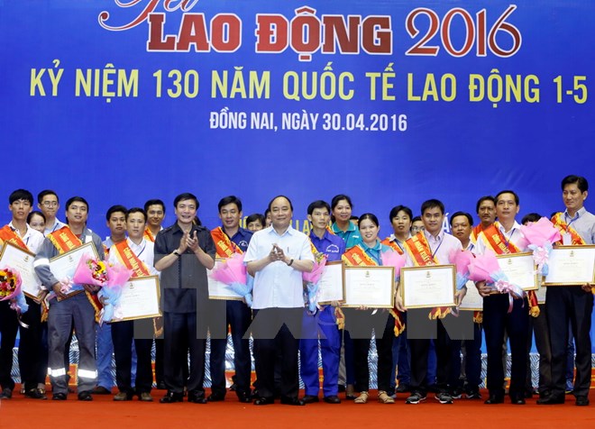 Thủ tướng Nguyễn Xuân Phúc trao tặng Bằng khen của Tổng Liên đoàn Lao động Việt Nam cho công nhân, người lao động tiểu biểu của 8 tỉnh, thành phố khu vực phía Nam. (Ảnh: Thống Nhất/TTXVN)