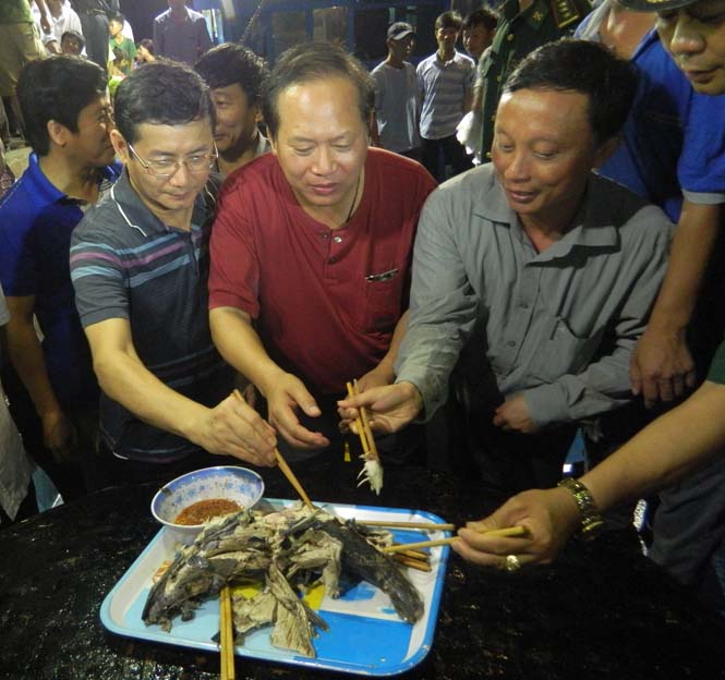 Đồng chí Trương Minh Tuấn, Ủy viên Trung ương Đảng, Bộ trưởng Bộ Thông tin và Truyền thông và các đồng chí lãnh đạo tỉnh ăn cá ngừ vừa được ngư dân Bảo Ninh đánh bắt xa bờ về.